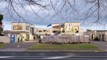 Een modern gebouw met een bord waarop staat dat het een Motor Inn & Conference Centre is.