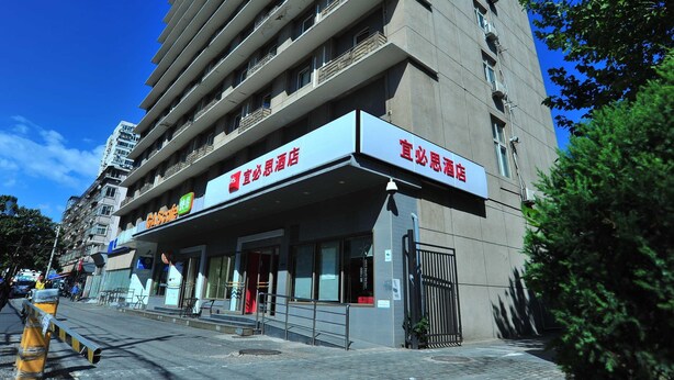 A hotel with a modern design, featuring a prominent entrance and multiple balconies.