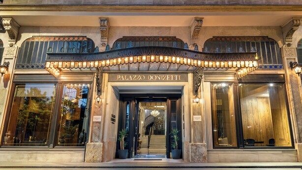 A grand entrance with a sign reading 'PALAZZO DONIZETTI,' a staircase, and large windows. - Palazzo Donizetti Istanbul, Tapestry Collection by Hilton (Istanbul)