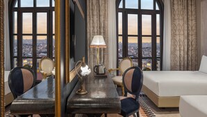 A hotel room with a large window, a bed, a desk with a lamp, and a chair. - Palazzo Donizetti Istanbul, Tapestry Collection by Hilton (Istanbul)