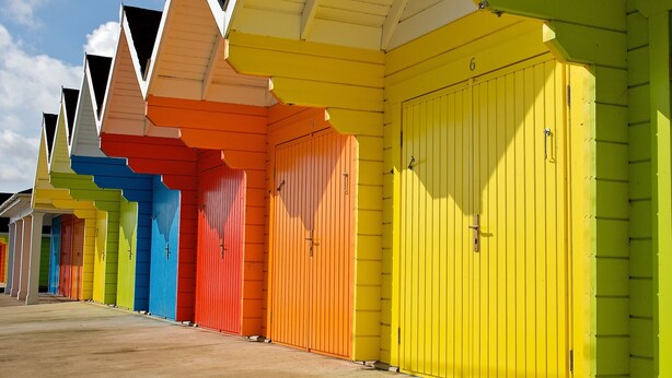 A row of brightly colored beach huts with a simple, functional design. - Palm Court Hotel (Scarborough)