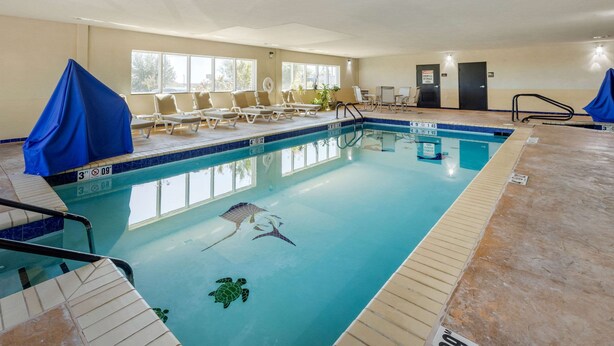 En inomhuspool med tydliga markeringar för banorna, solstolar och en livräddarstol.