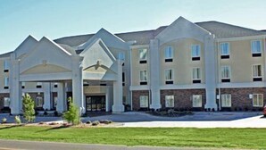 A multi-story hotel with a central entrance, large windows, and a covered outdoor area.