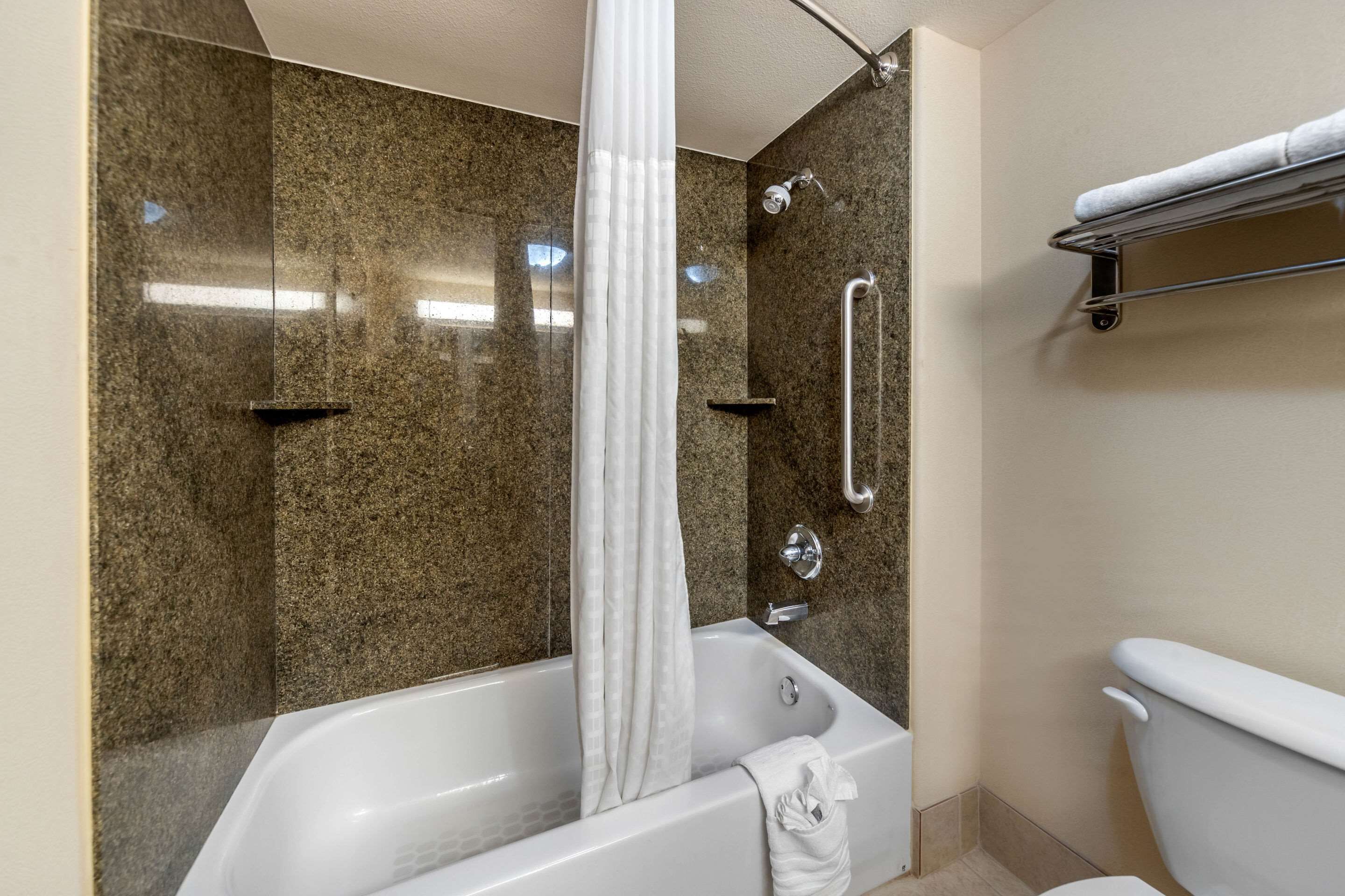 A bathroom with a bathtub, shower, and toilet.