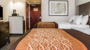 A hotel room with a bed, a dresser, a television, and a framed picture on the wall.