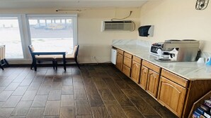 Una cocina con armarios de madera, una encimera y un ventanal con vista a la calle.