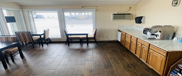 Una cocina con armarios de madera, una encimera y un ventanal con vista a la calle.