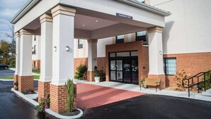 Een hotel ingang met een overdekte gangpad, een duidelijk bord met 14 voet vrije hoogte, en een gevel van baksteen.