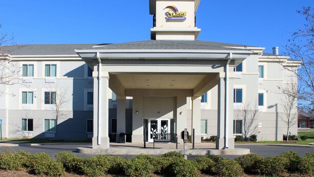 A hotel entrance with a covered porch, a sign above the entrance, and a clear blue sky. - Sleep Inn & Suites Evergreen I-65 (Evergreen)