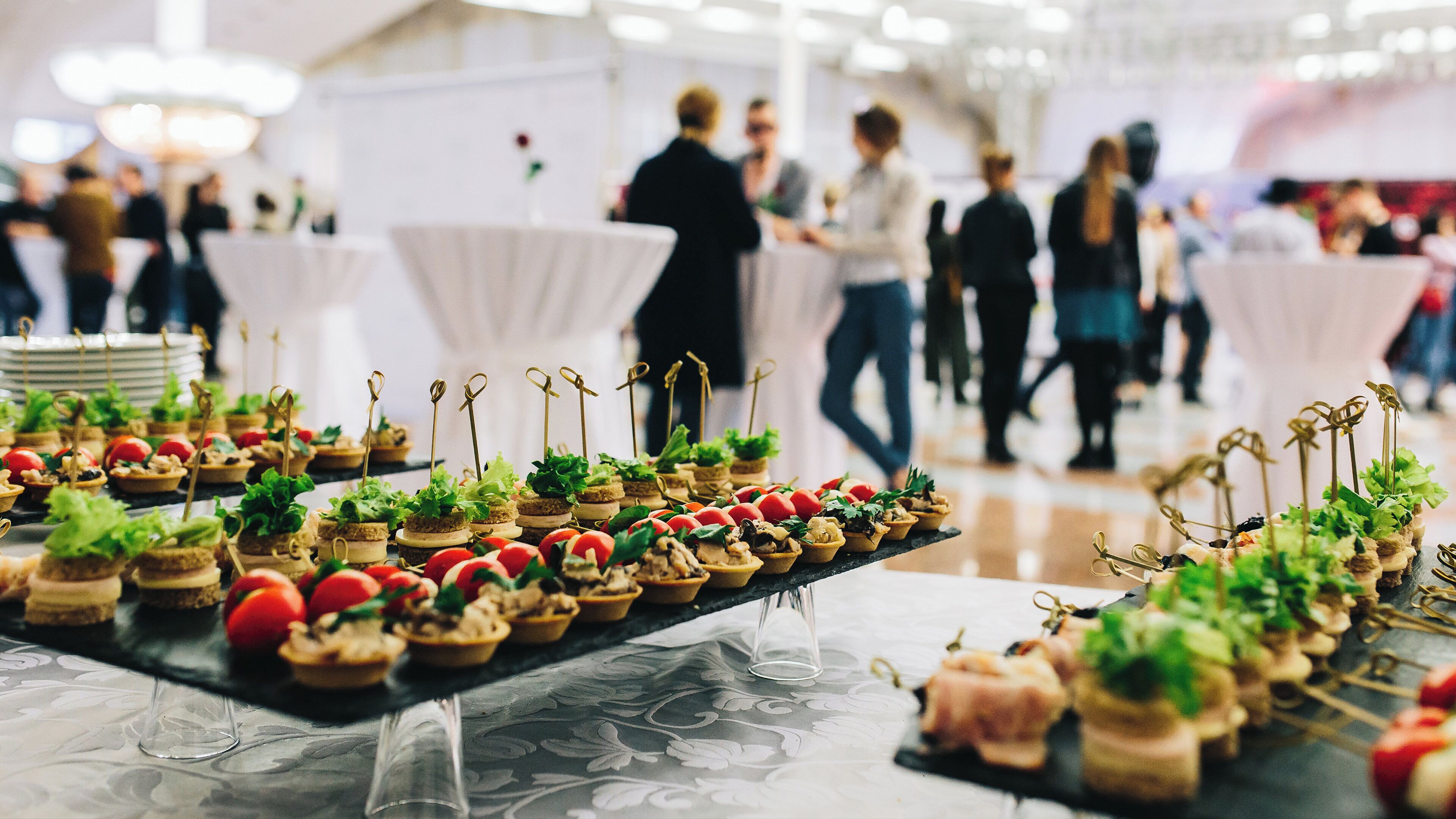 A buffet table with various food items and a glass of water.