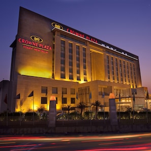 Un hotel con un cartello ben visibile che riporta le scritte "Crown Plaza" e "Today New Delhi".