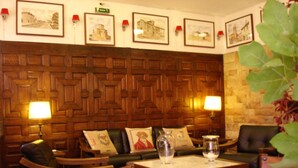 A lobby with wooden paneling, leather seating, and framed pictures on the wall. - Tierra De Campos (Osorno)