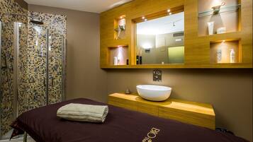 Un bagno moderno con doccia in mosaico, uno specchio grande e un mobile bagno in legno con lavabo.