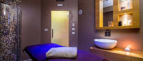 A modern bathroom with a large mirror, a white sink, and a shower area.