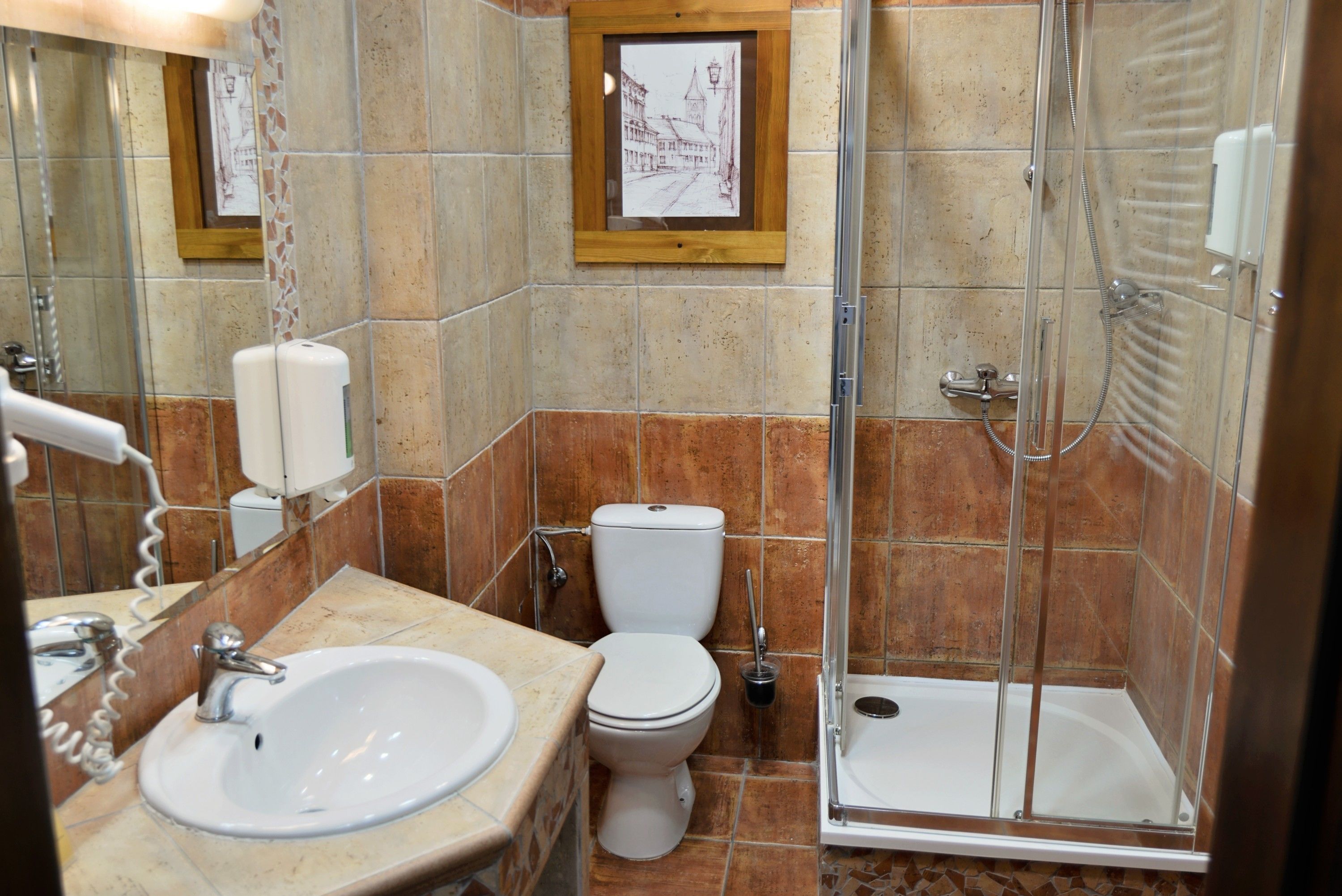 A bathroom with a sink, toilet, and glass-enclosed shower.