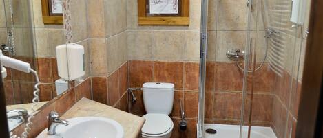 A bathroom with a sink, toilet, and glass-enclosed shower.