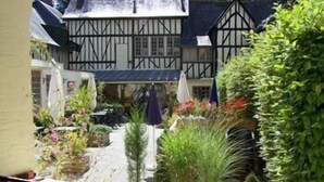 Un bâtiment traditionnel à colombages, avec un jardin à l’avant.