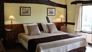 Une chambre à coucher avec un grand lit, deux tables de chevet avec des lampes et une fenêtre avec des rideaux.