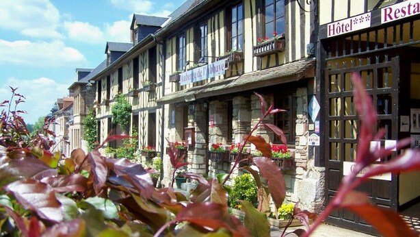 Un bâtiment européen traditionnel, avec une enseigne indiquant « Hôtel de l’Abbaye » et un restaurant.