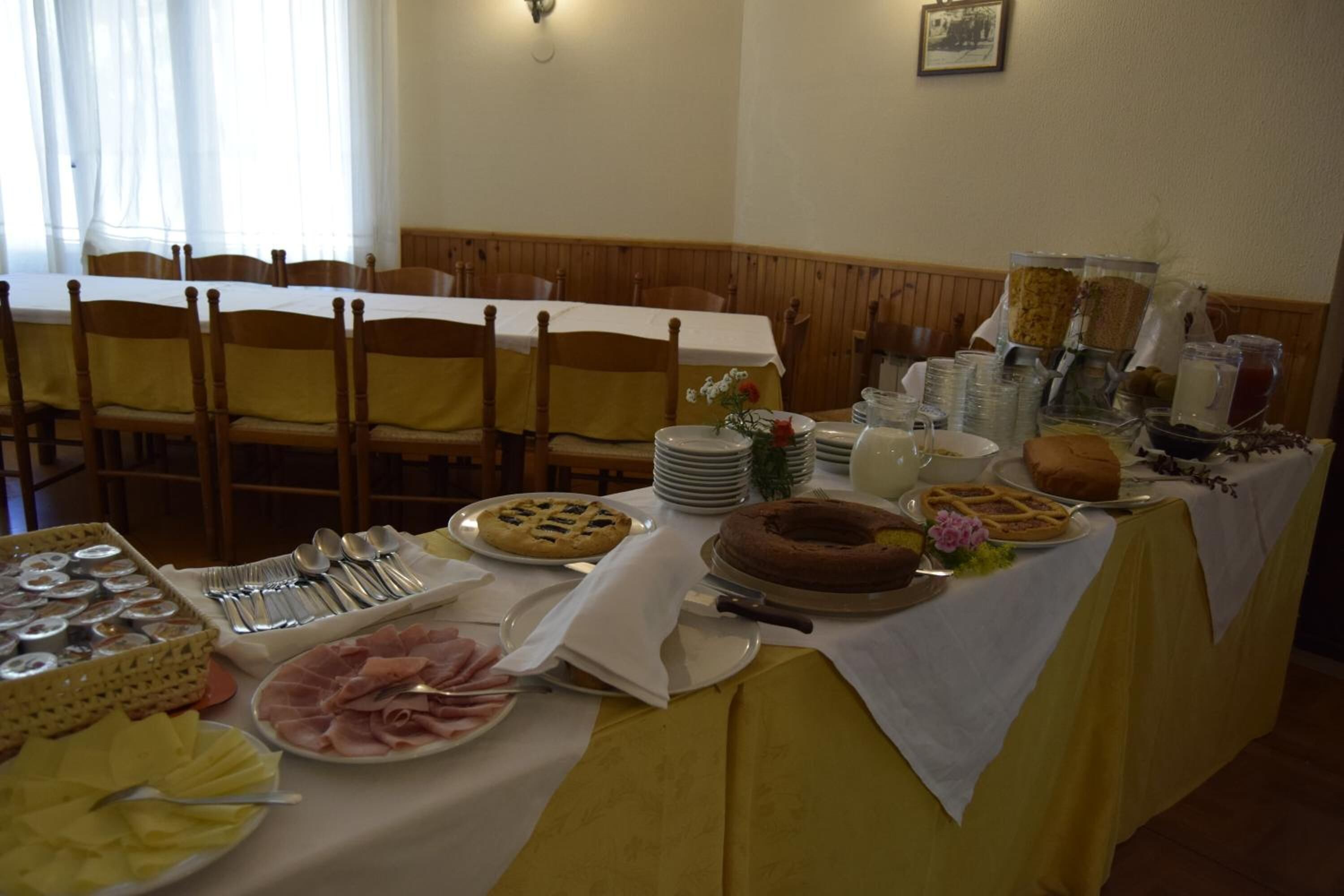 A buffet table with various food items and utensils.