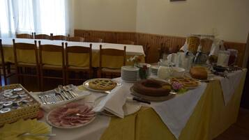 A buffet table with various food items and utensils.