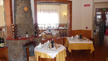 Un ristorante con pareti in mattoni, un pilastro in pietra e diversi tavoli apparecchiati.