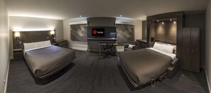 A modern hotel room with two beds, a desk, a TV, and a wardrobe. - Hôtel & Suites Normandin Lévis (Levis)