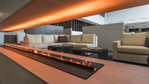 Un espace de vie moderne comprenant une longue et étroite cheminée, un canapé et une table basse.