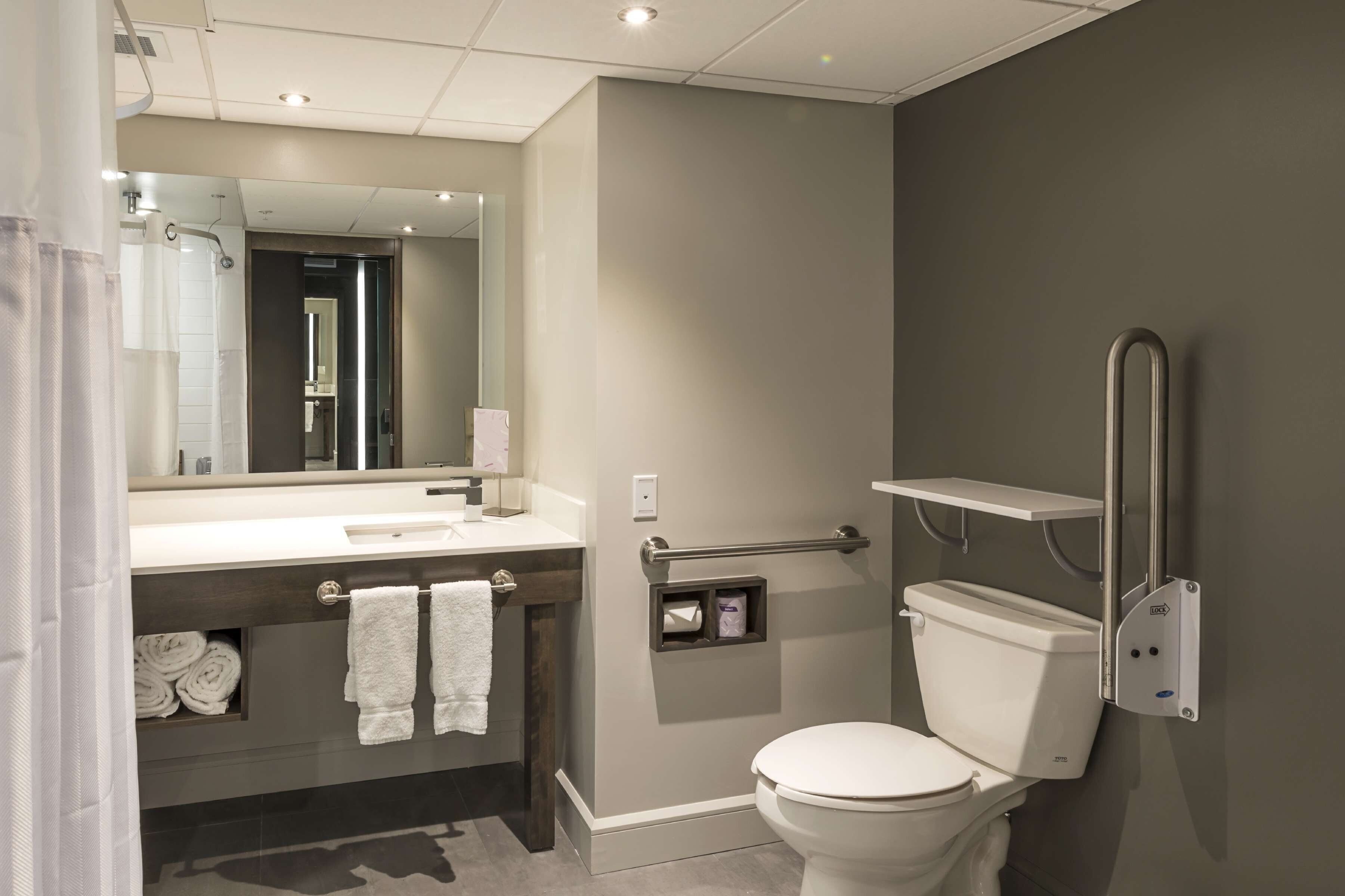 A modern bathroom with a toilet, sink, and shower.