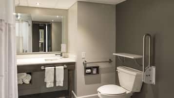 A modern bathroom with a toilet, sink, and shower.