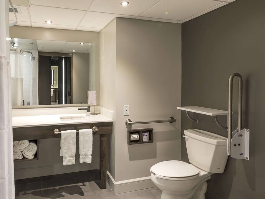 A modern bathroom with a toilet, sink, and shower.
