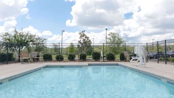 Una piscina al aire libre, sombrillas, tumbonas