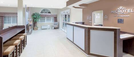 A reception area with a reception desk, seating area, and a large window.