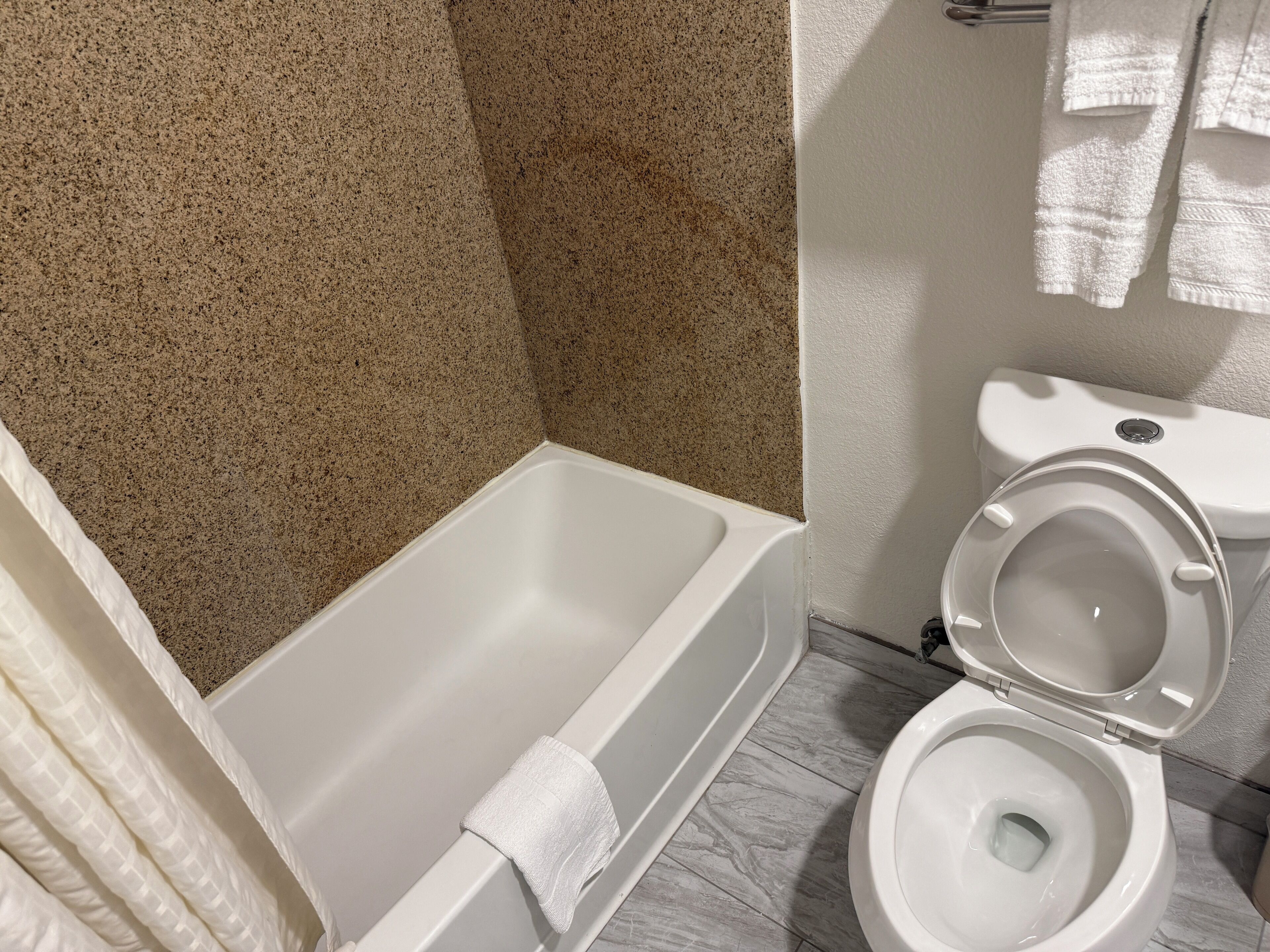 Baño con bañera, inodoro y zona de ducha.