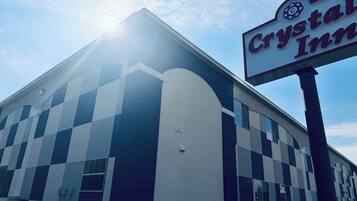 A building with a checkered facade, a sign reading 'Crystal Inn,' and a clear sky.