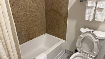 A bathroom with a bathtub, toilet, and a towel rack.