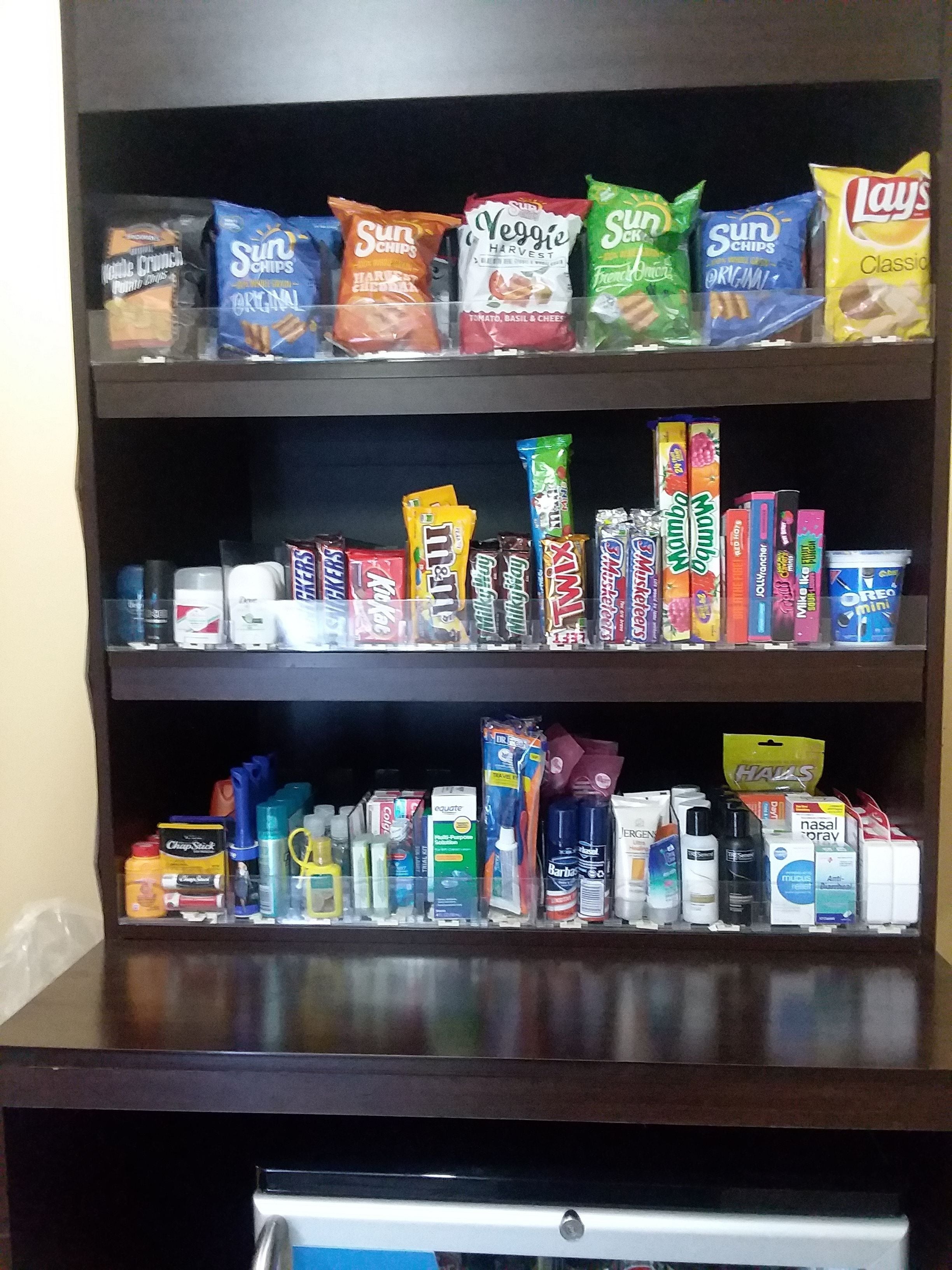 A shelf stocked with snacks, candies, and personal care items.