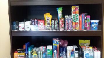 A shelf stocked with snacks, candies, and personal care items.