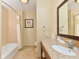 Un baño con bañera, lavamanos, espejo y cortina de ducha.