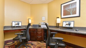 A hotel reception area with two computer workstations, a desk with a printer, and two office chairs. - Hampton Inn Muscatine (Muscatine)