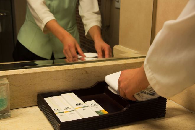 A hotel reception area with a counter, a tray of cards, and a glass container.