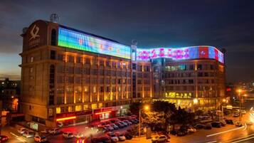 A multi-story hotel with a prominent curved corner and illuminated signage.