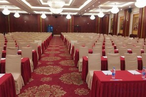 A conference room with rows of tables and chairs, a red carpet, and a chandelier. - Plateau Pearl Hotel (Kunming Yongzhong Road) (Kunming)
