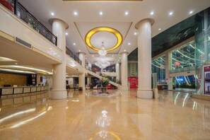 A spacious lobby with a central staircase, a reception desk, and a chandelier. - Plateau Pearl Hotel (Kunming Yongzhong Road) (Kunming)