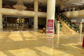 A spacious lobby with a marble floor, a reception desk, a staircase, and a hanging chandelier. - Plateau Pearl Hotel (Kunming Yongzhong Road) (Kunming)