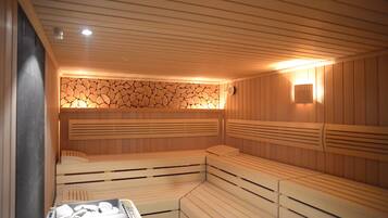 Eine Sauna mit Holzbänken und einer Steinwand.