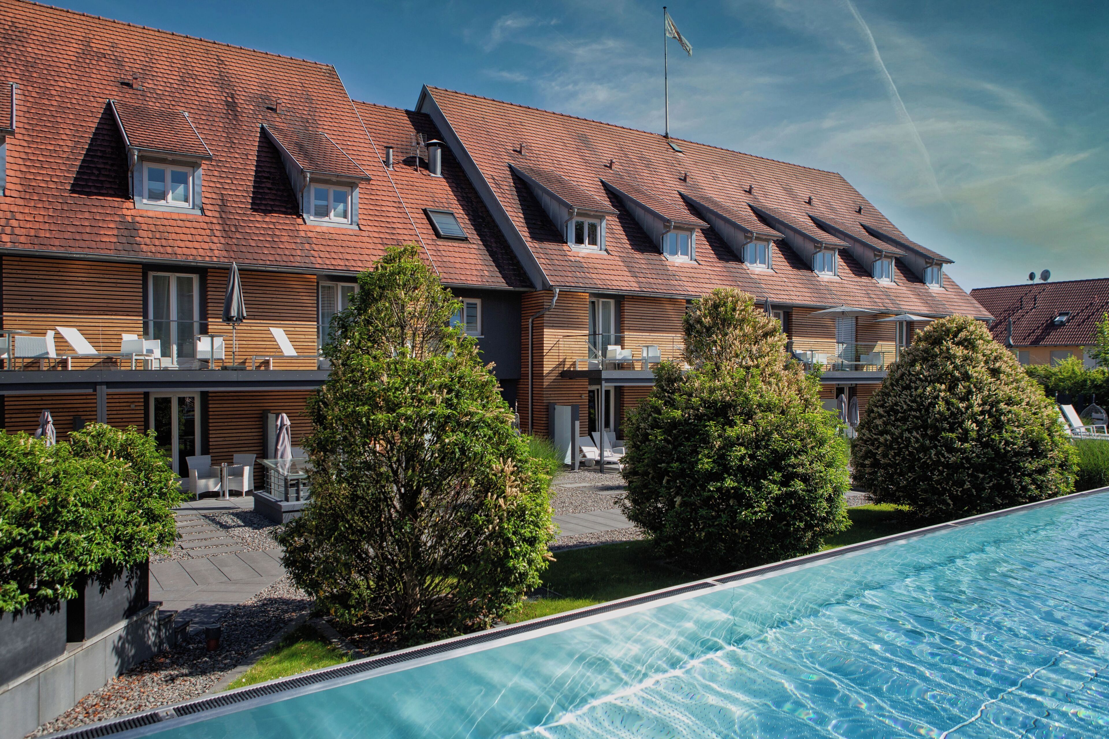 Un hôtel moderne doté d’une piscine, de nombreux balcons et d’un jardin bien entretenu.