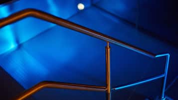 Ein metallisches Geländer mit einem geometrischen Muster, vermutlich Teil einer Treppe oder eines Balkons.