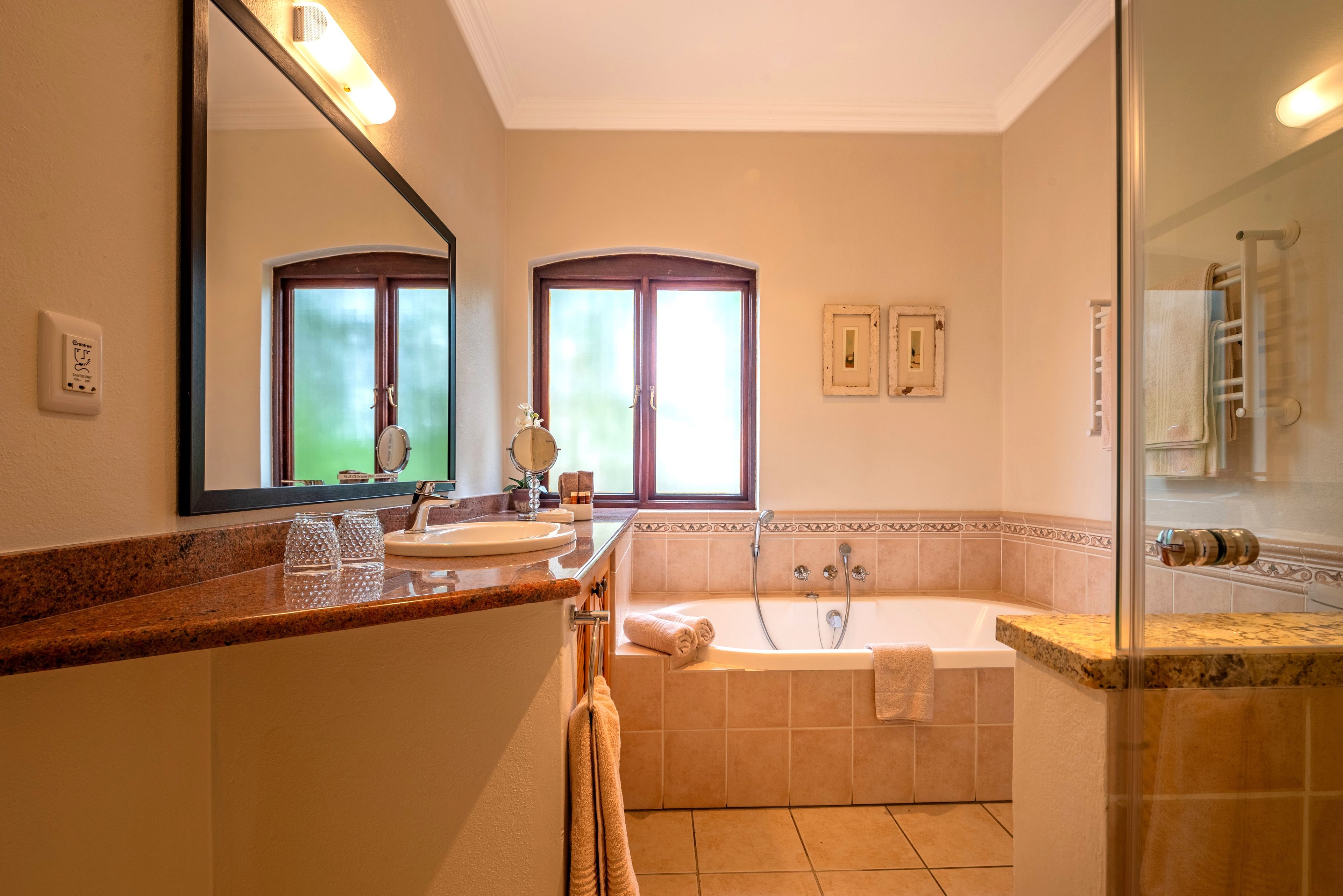 A bathroom with a bathtub, a sink, a mirror, and a towel rack.