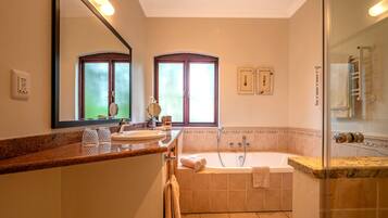 A bathroom with a bathtub, a sink, a mirror, and a towel rack.